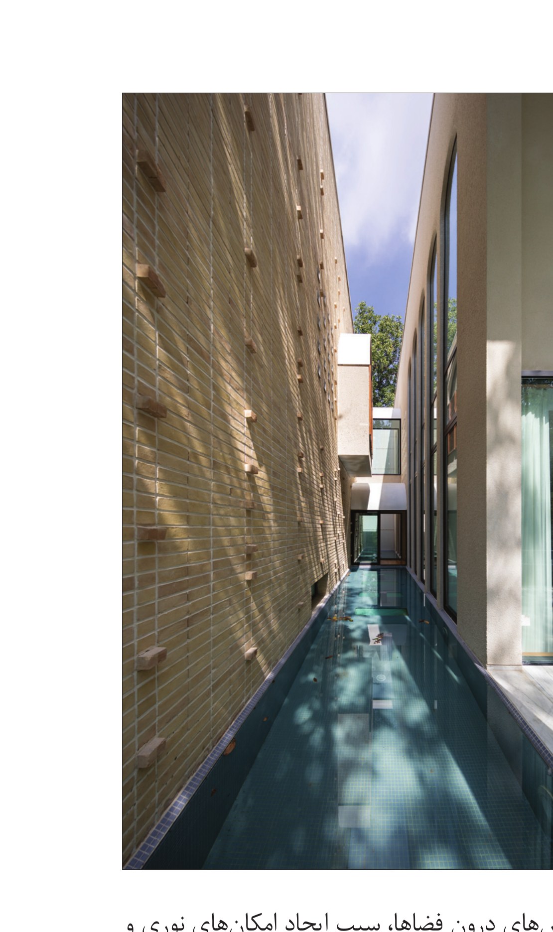 Narrow water passage between brick wall and glass facade