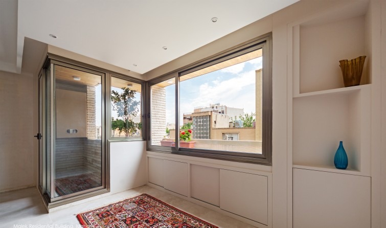 Malek Residential Building — a top-floor small courtyard with a skylight above