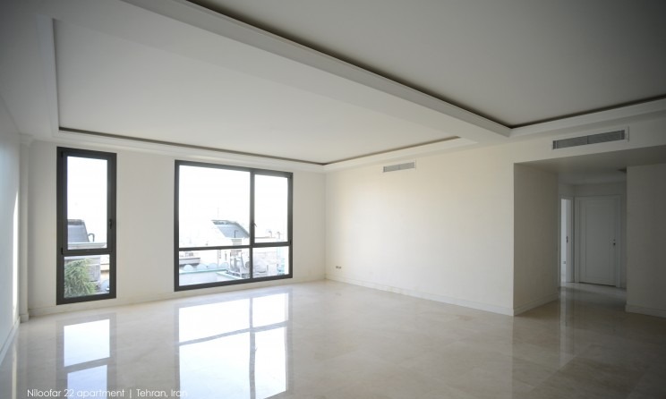 Interior of a Niloofar 22 apartment unit with large glazed openings framing the city beyond