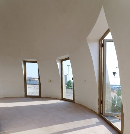 Rong Cultural Center at Persian Gulf sunset — the domes silhouetted against the orange sky