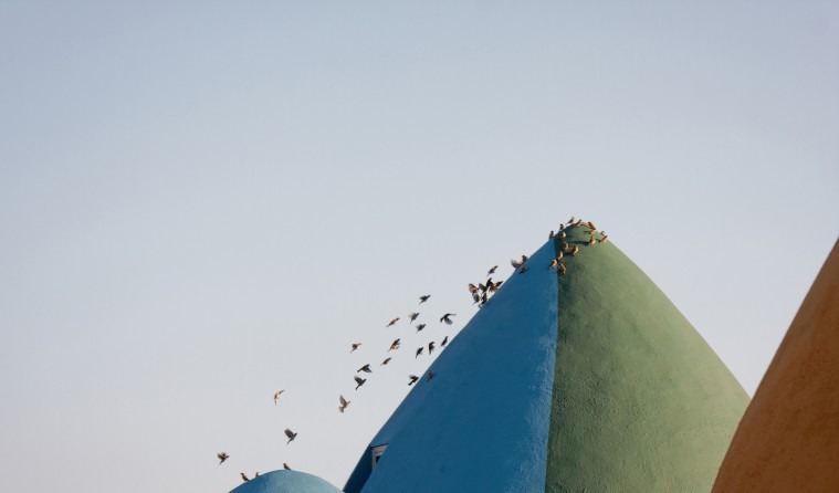 Three domes in blue, green and ochre with birds in flight