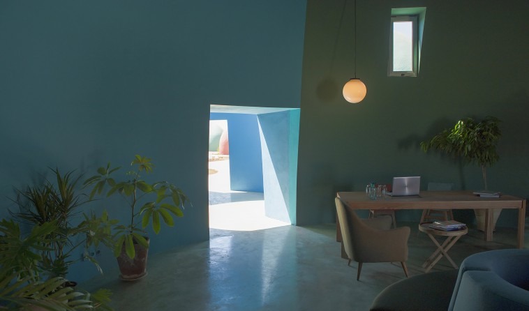 Interior with teal walls and a portal to the blue courtyard