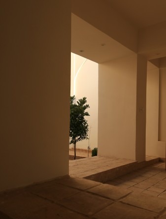 نمای مرمت‌شده رو به کوچه، با پنجره بالای در که گذر را می‌نگرد.