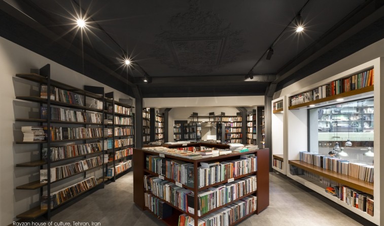 Bookstore interior of Rayzan House of Culture with the original ornate stucco ceiling above contemporary black shelving