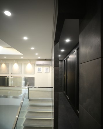 A glazed corner showroom on the showroom's upper level showing a small tiled wall sample inside a glass box