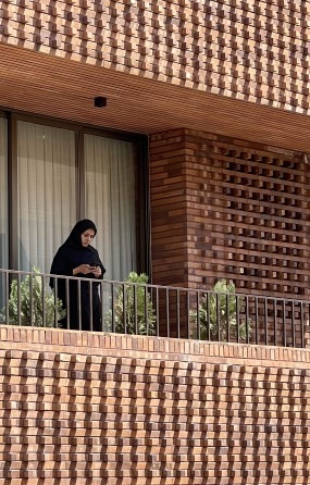 ساکنی پشت شبکه آجری ـــ دیوار هم‌زمان مانع نگاه از بیرون می‌شود و نگاهِ بیرون را قاب می‌گیرد.