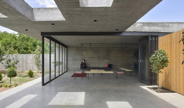 The main interior in its open state: the steel-frame sliding doors are folded into the corners, joining the floor of the