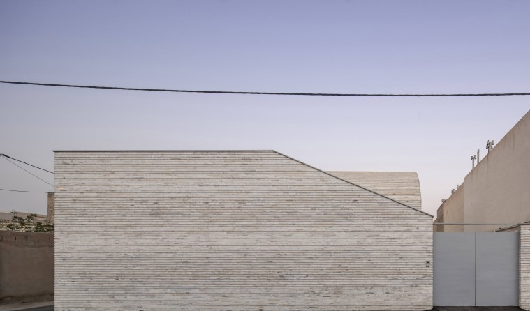 Twilight side view of the flat stone facade against the bare sky