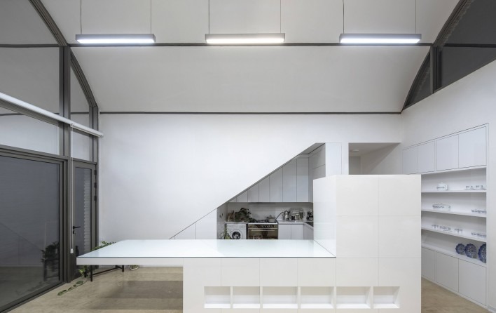 Interior view from the kitchen looking up at the vault ceiling with linear lights and the rear skylight