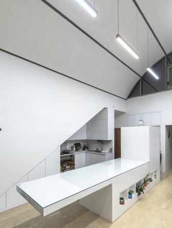 Close view of the kitchen counter island under the steeply rising vault wall