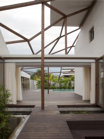 Vanoosh Villa at dusk — a small pavilion lit from within sits in the landscape with the linked deck to the right