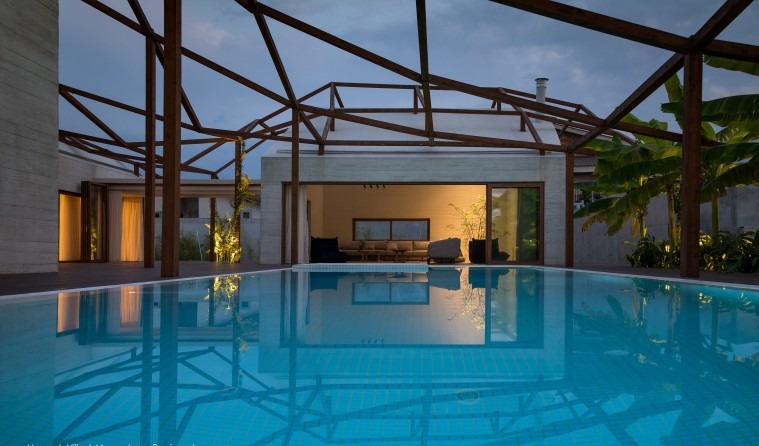 A double-height covered living/dining room of Vanoosh Villa with the trellis roof above the cedar interior
